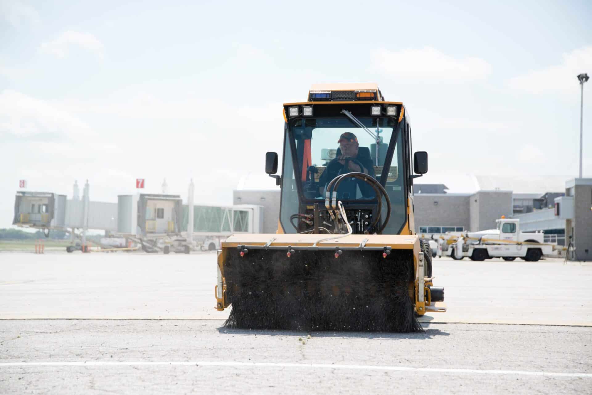 trackless vehicles mt6 with power angle sweeper attachment sweeping the tarmac at an airport