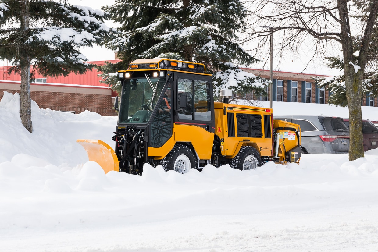 trackless vehicles double trip plow attachment on sidewalk tractor in snow side view