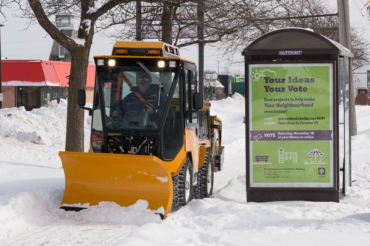 trackless vehicles double trip plow attachment on sidewalk tractor in snow front view