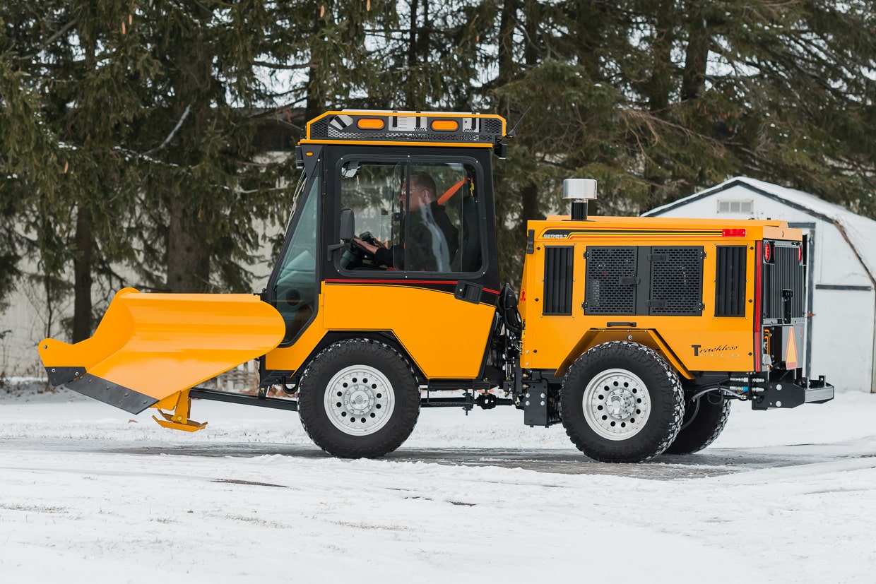 trackless vehicles fixed wing v-plow attachment on sidewalk tractor in snow side view