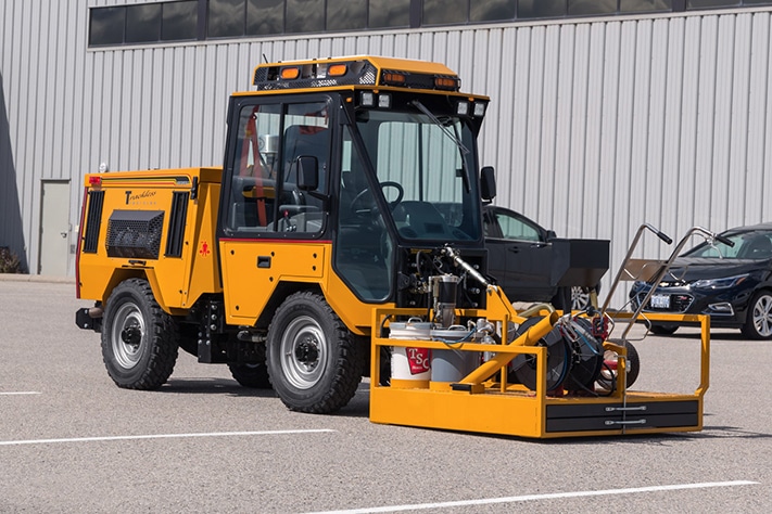 trackless vehicles line and stencil painter attachment on sidewalk tractor side view