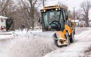 trackless vehicles power angle sweeper attachment on sidewalk municipal tractor working on sidewalk front view in snow