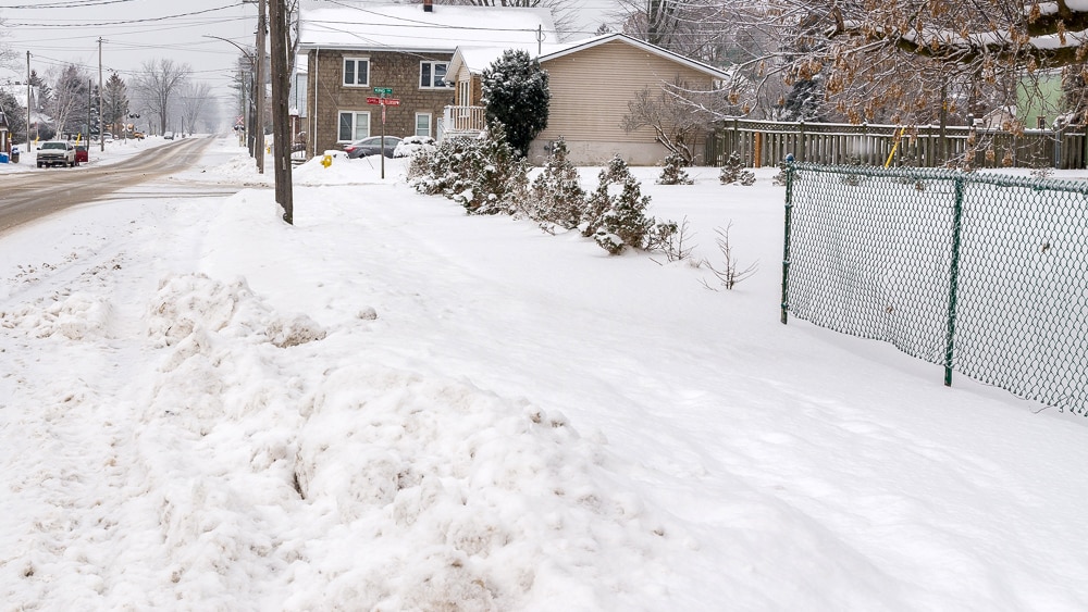 snow on ground before trackless vehicles 5-position folding v-plow attachment on sidewalk tractor