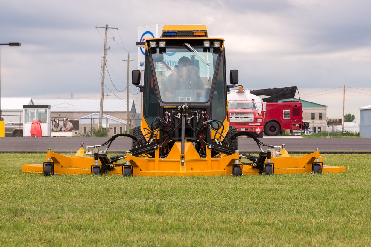 trackless vehicles rotary finishing mower 14' attachment on sidewalk municipal tractor mowing grass front view