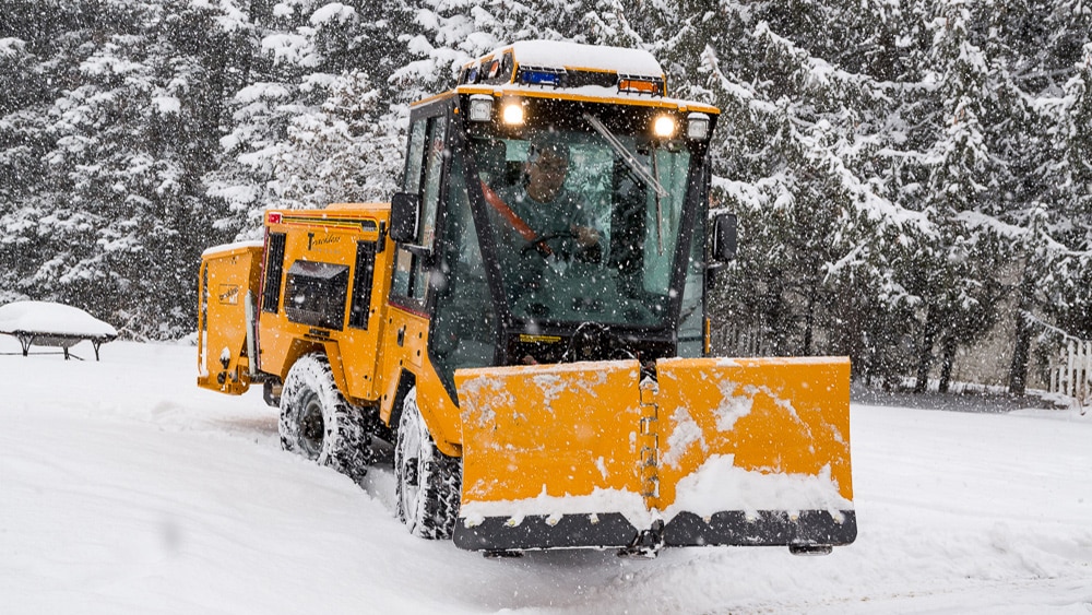 trackless vehicles 5-position folding v-plow attachment on sidewalk tractor in snow front view