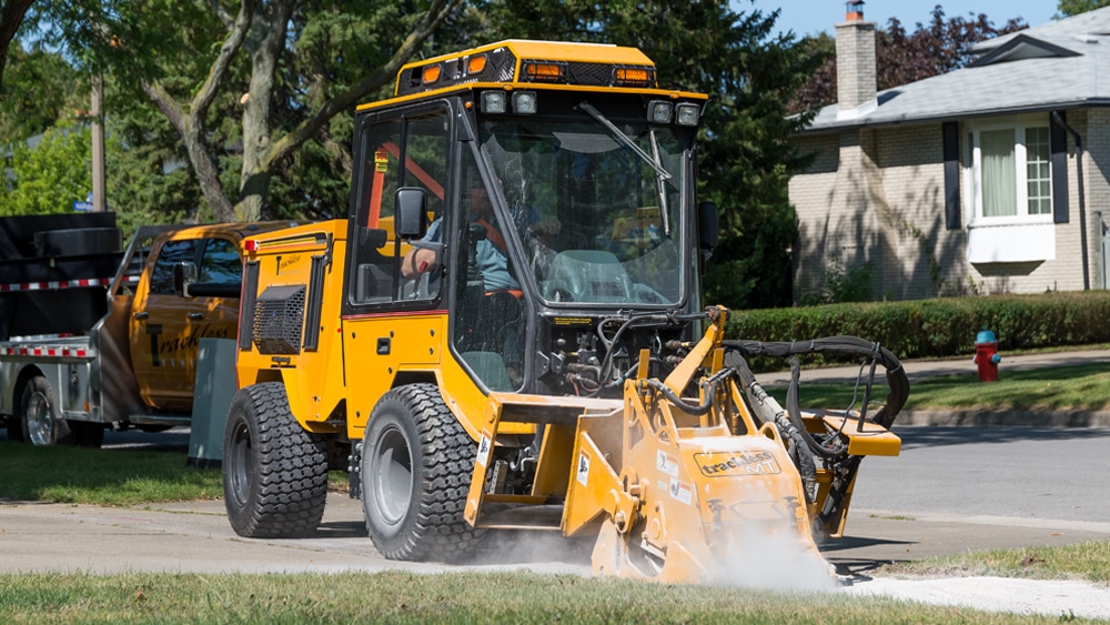 trackless vehicles cold planer attachment on sidewalk tractor working on sidewalk side view